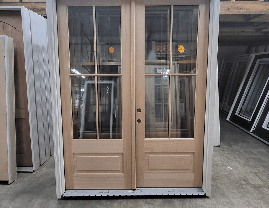 Wooden french doors with glass panes and bronze doorknobs in warehouse setting